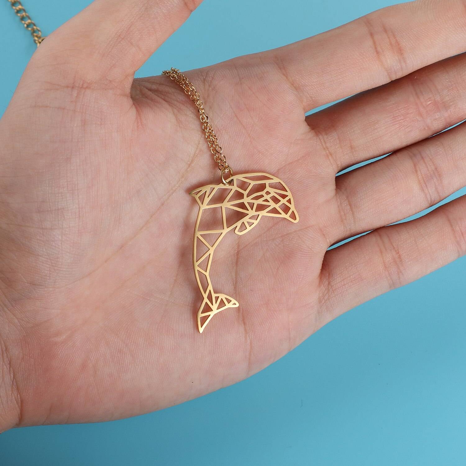 Playful Dolphin Origami Necklace on hand